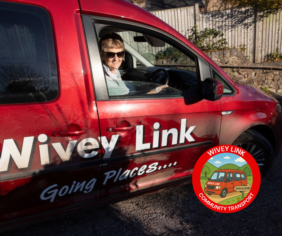A woman in singlasses sits smiling in the driver seat of a red Wivey Link car.